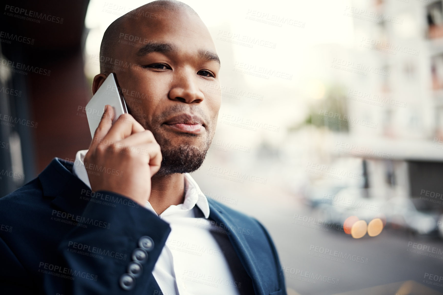 Buy stock photo Shot of a handsome young businessman talking on a cellphone outside his office