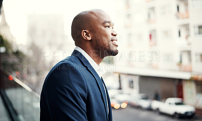 Buy stock photo Shot of a handsome young businessman standing outside on his office balcony