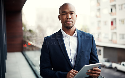 Buy stock photo Portrait of a handsome young businessman using a digital tablet outside his office