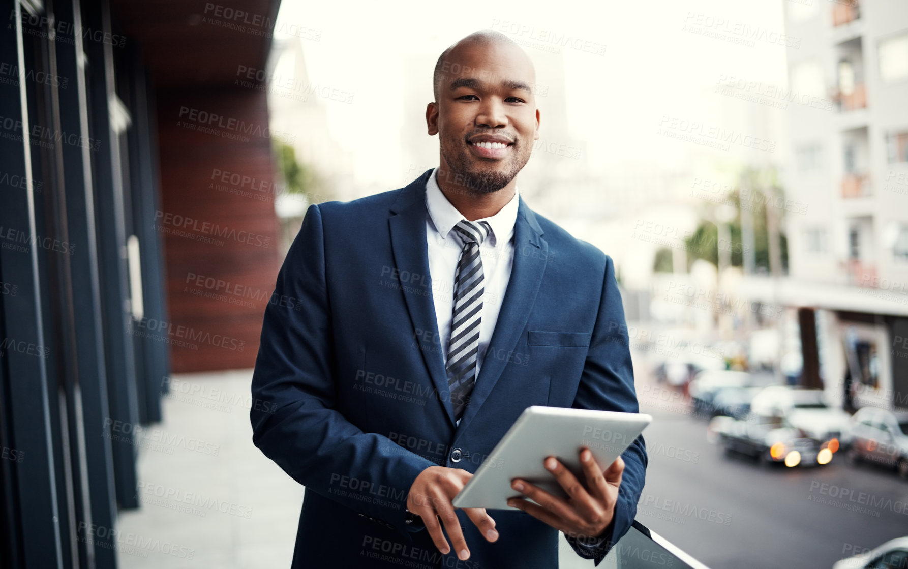 Buy stock photo Portrait of a handsome young businessman using a digital tablet outside his office