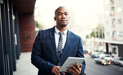 Buy stock photo Portrait of a handsome young businessman using a digital tablet outside his office