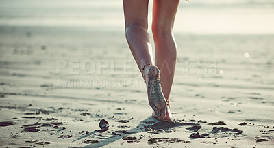 Buy stock photo Cropped shot of an unrecognizable woman walking on the beach