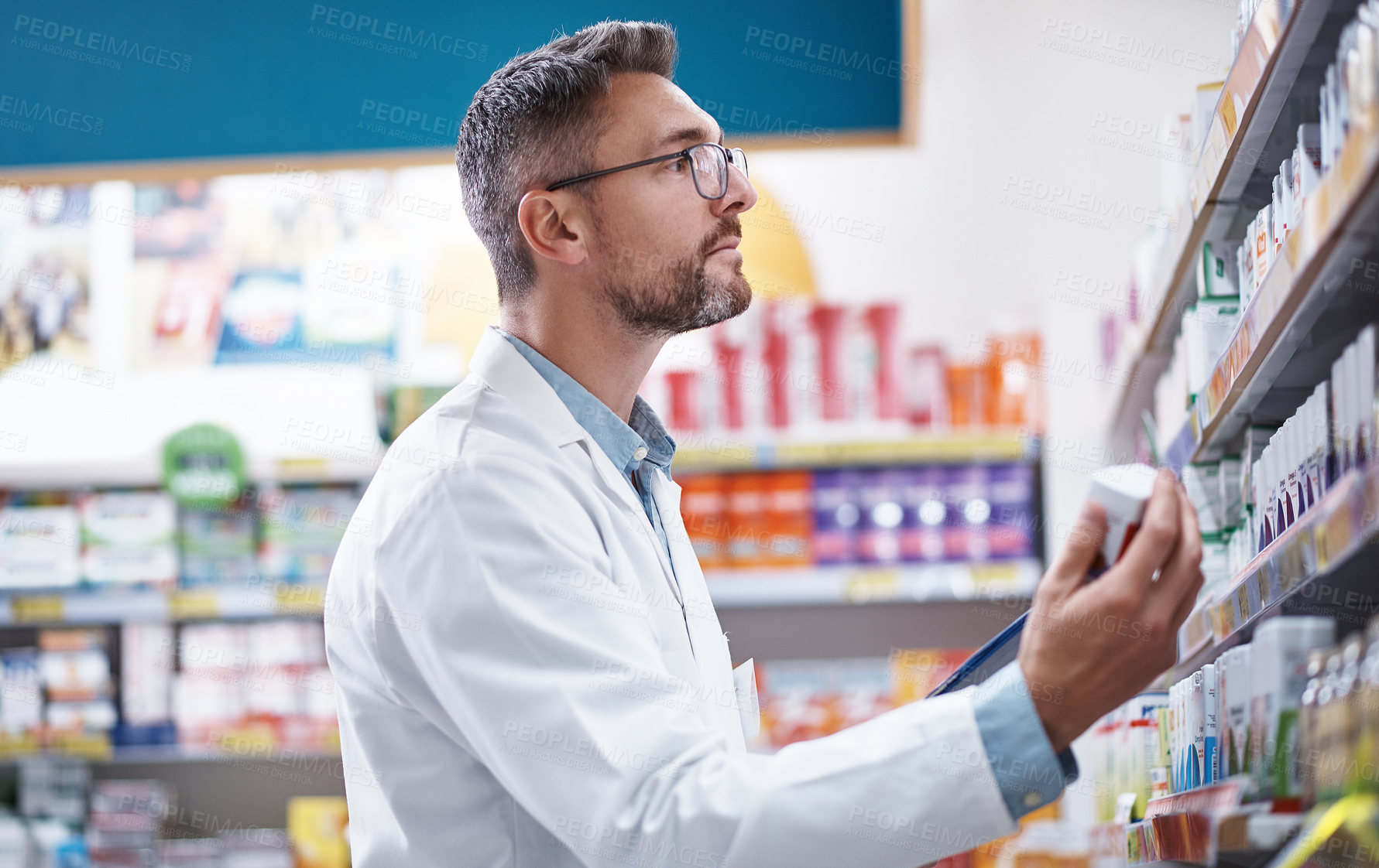 Buy stock photo Shot of a mature pharmacist doing inventory in a pharmacy