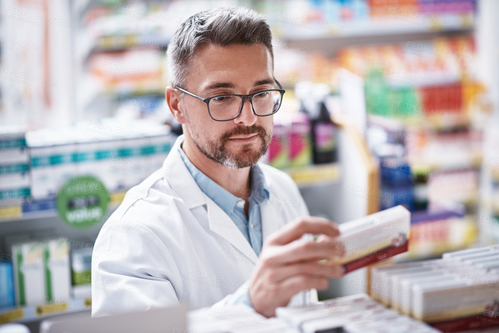 Buy stock photo Shot of a mature pharmacist doing inventory in a pharmacy