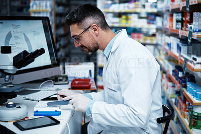 Buy stock photo Shot of a mature pharmacist counting medication
