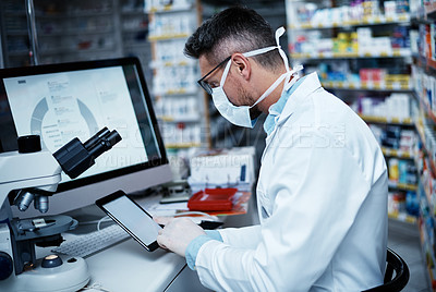 Buy stock photo Shot of a mature man using a digital tablet while conducting pharmaceutical research