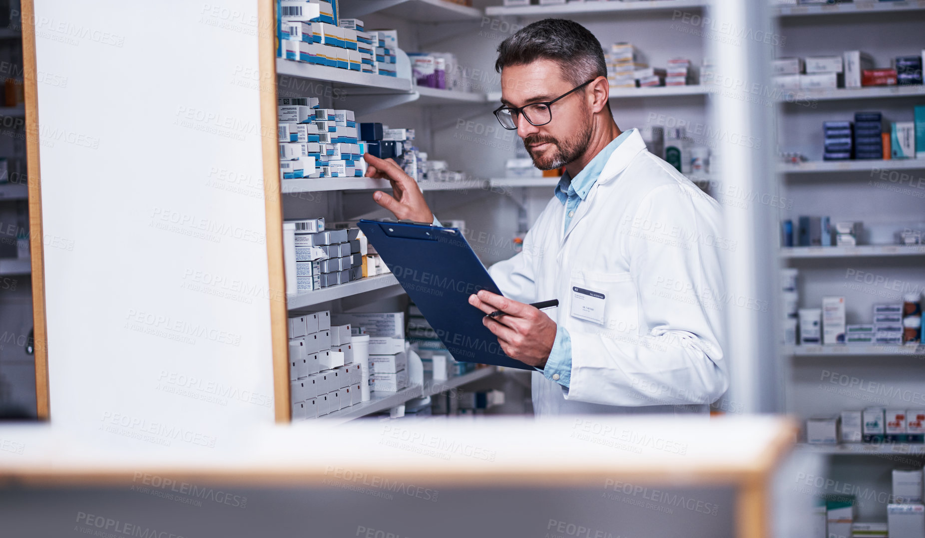 Buy stock photo Shot of a mature pharmacist doing inventory in a pharmacy