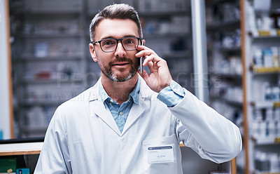 Buy stock photo Portrait of a mature pharmacist talking on a cellphone in a pharmacy