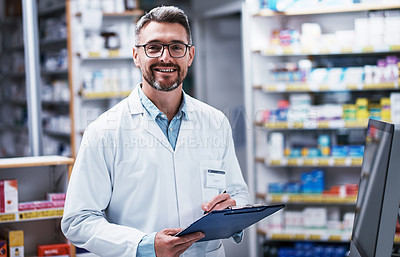 Buy stock photo Portrait of a mature pharmacist writing on a clipboard in a pharmacy