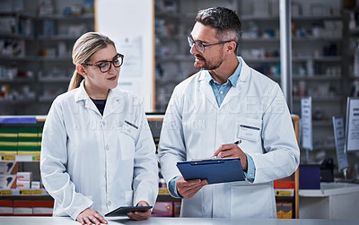 Buy stock photo Shot of two pharmacists working in a pharmacy