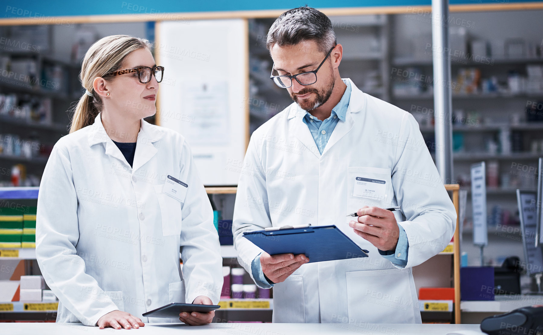 Buy stock photo Shot of two pharmacists working in a pharmacy