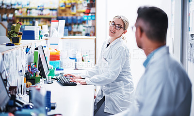 Buy stock photo Shot of two pharmacists working in a pharmacy
