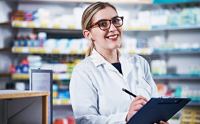 Buy stock photo Portrait of a young pharmacist writing on a clipboard in a pharmacy