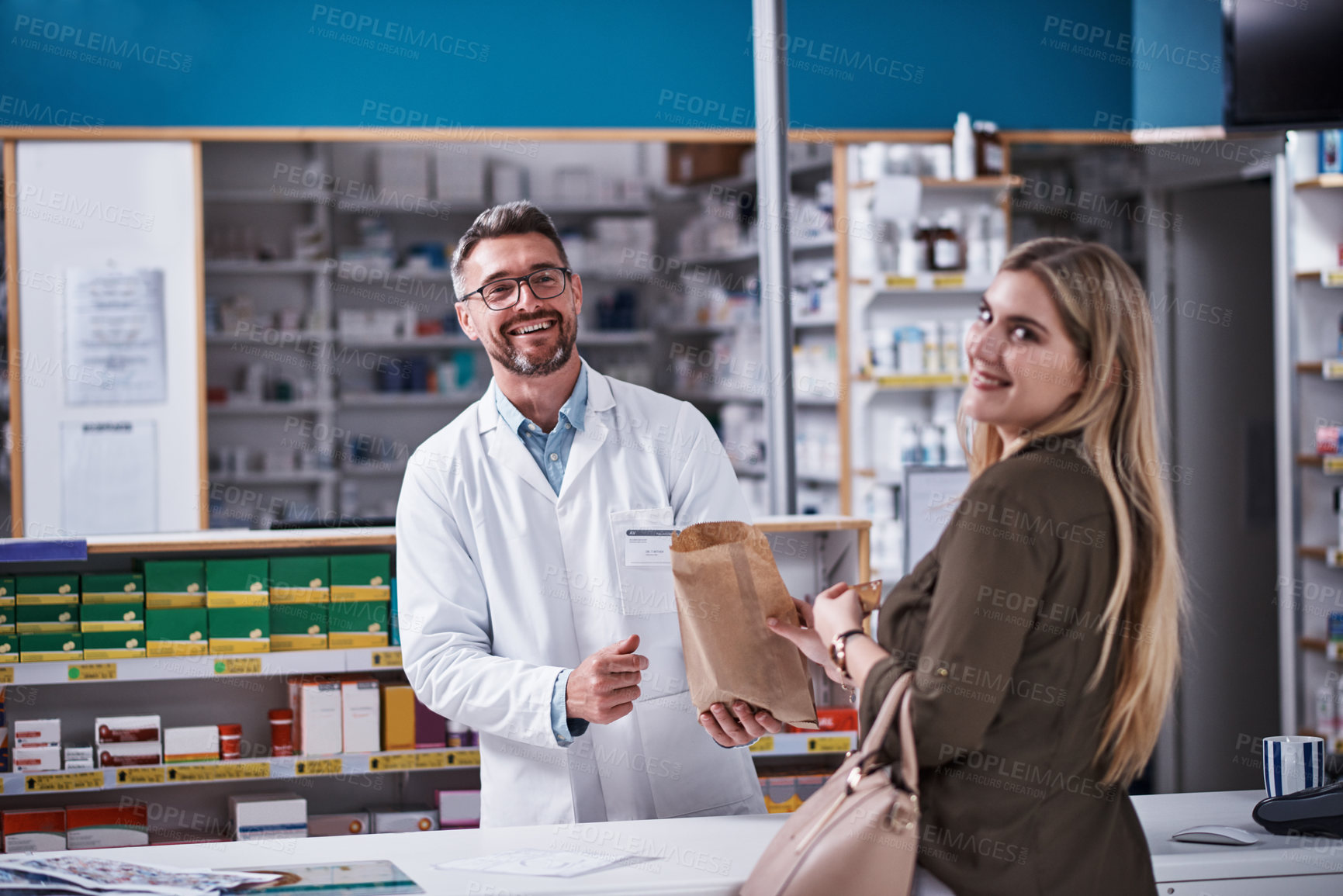 Buy stock photo Portrait of a mature pharmacist assisting a young woman in a chemist