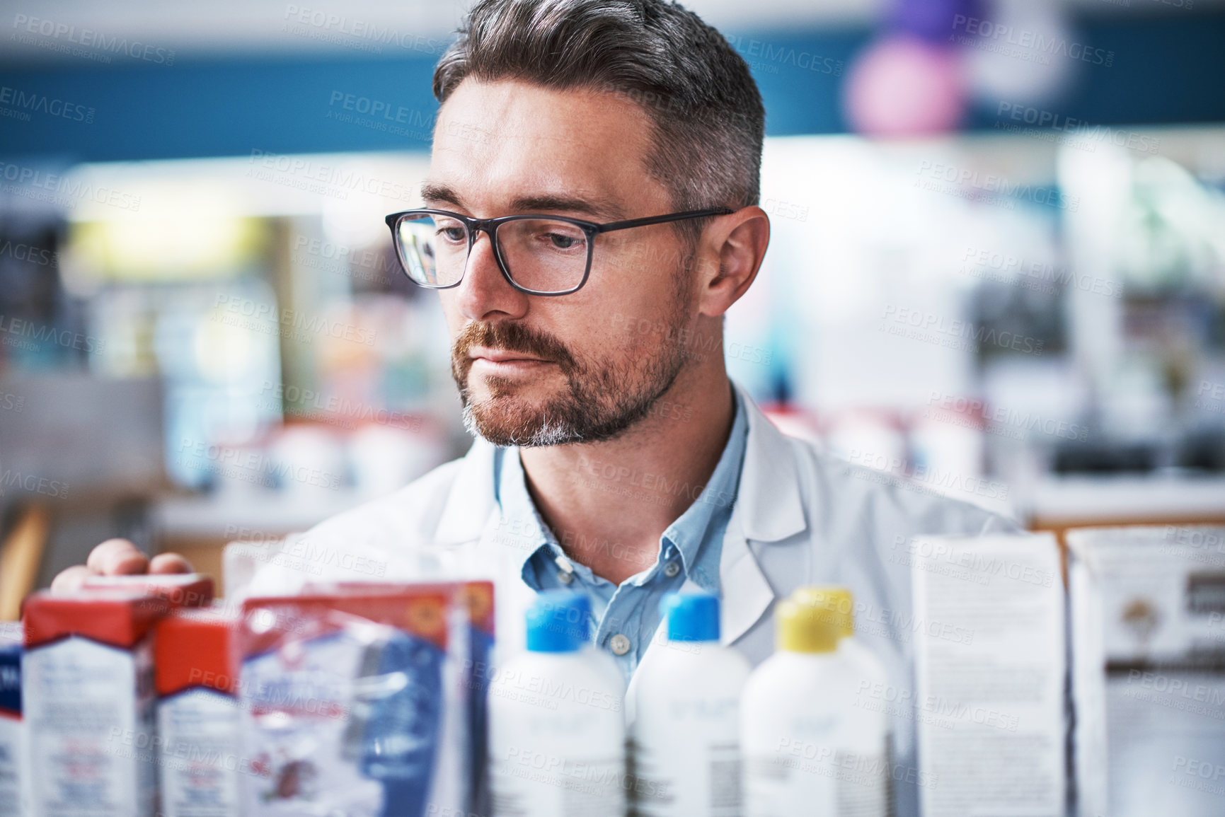 Buy stock photo Shot of a mature pharmacist checking products in a pharmacy