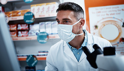 Buy stock photo Shot of a mature man using a computer while working in a pharmacy