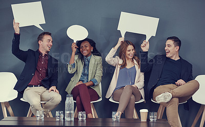 Buy stock photo Shot of a group of businesspeople holding up speech bubbles while waiting in line for an interview
