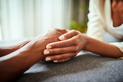Buy stock photo Closeup of two unrecognizable people's hands holding each other while resting on top of a  table