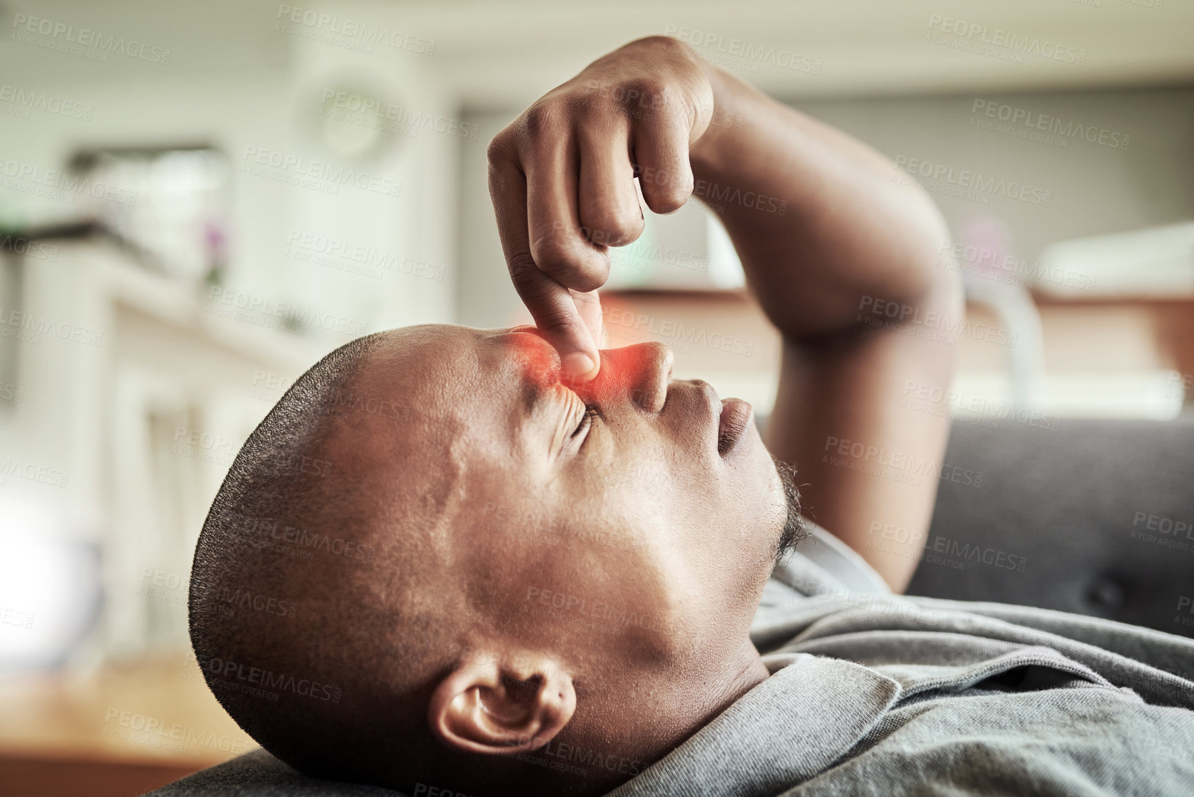 Buy stock photo Black man, headache and pain with stress on sofa for vertigo, dizziness or fatigue at home. Young African, male person or strain with red glow or migraine for anxiety, depression or pressure at house
