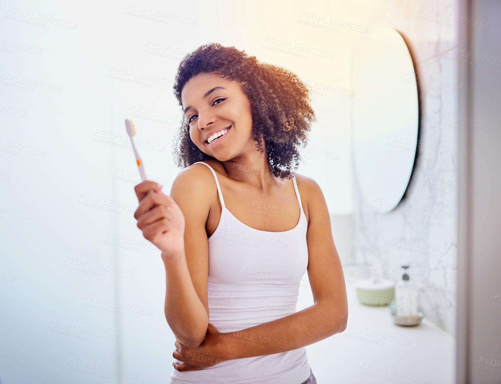 Buy stock photo Shot of an attractive young woman brushing her teeth in the bathroom at home