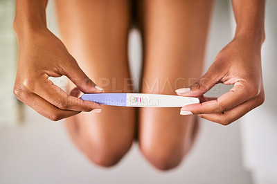 Buy stock photo Health, hands and closeup of a positive pregnancy test by a woman in the bathroom of her home. Maternity, motherhood and zoom of a female person with a pregnant stick with results in her modern house