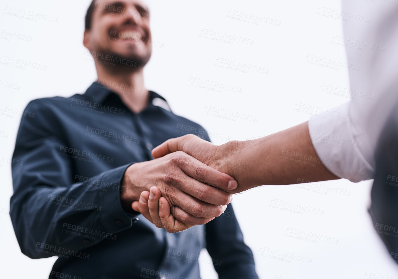 Buy stock photo Closeup shot of two unrecognizable businessmen shaking hands against a white background