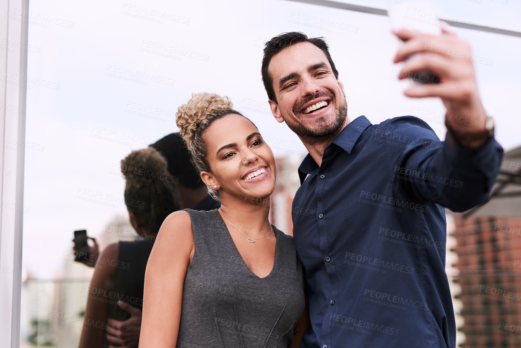 Buy stock photo Shot of two colleagues taking a selfie together outside an office