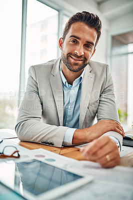 Buy stock photo Portrait of a handsome young businessman sitting in an office