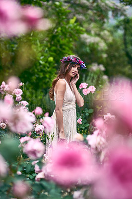 Buy stock photo Shot of a beautiful young woman wearing a floral head wreath posing in nature