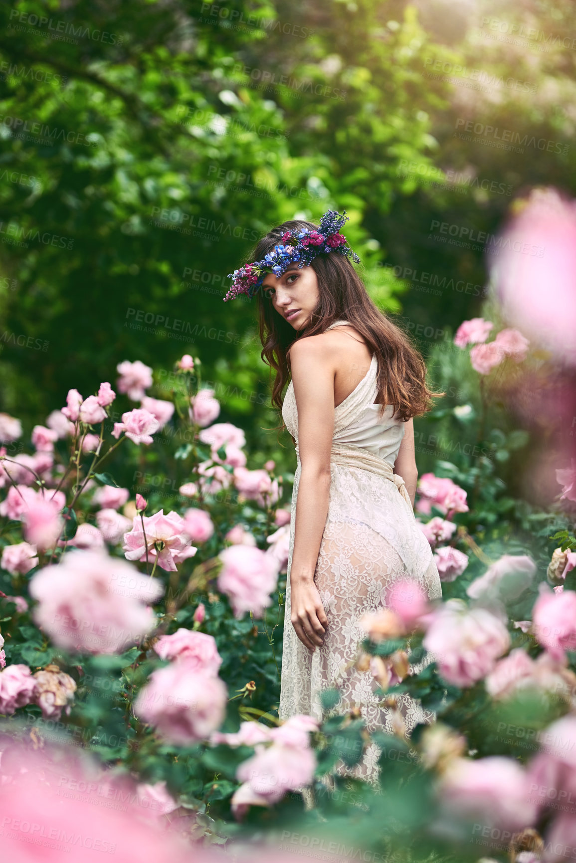 Buy stock photo Shot of a beautiful young woman wearing a floral head wreath posing in nature