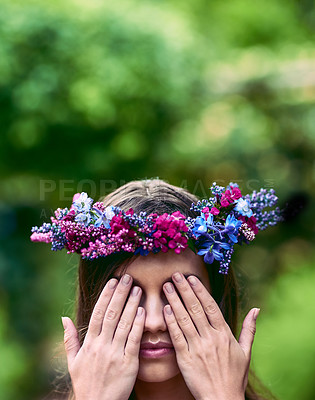 Buy stock photo Cropped shot of a beautiful young woman wearing a floral head wreath and covering her eyes in nature