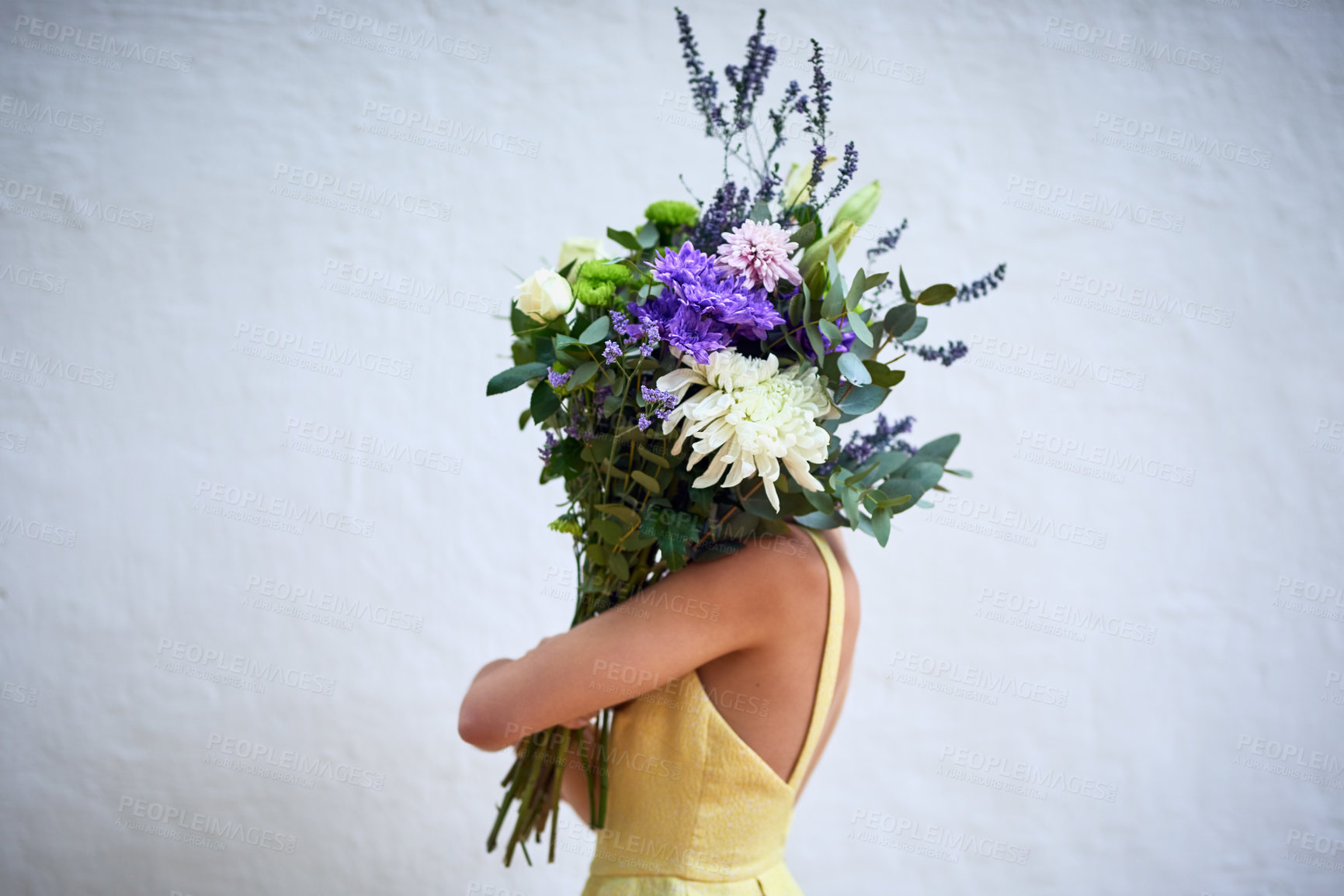 Buy stock photo Studio shot of an unrecognizable woman holding a bouquet of flowers while standing against a grey background