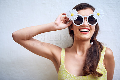 Buy stock photo Happy woman, portrait and flower sunglasses at wall for fashion, summer style and confidence. Student, quirky eyewear and excited in city for study break, freedom and brand accessories for aesthetic