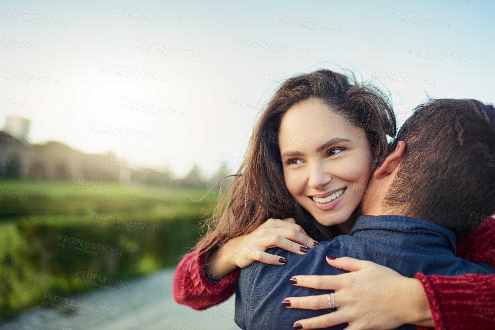 Buy stock photo Shot of a happy young couple embracing each other outdoors