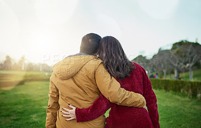 Buy stock photo Rearview shot of a young couple embracing each other outdoors