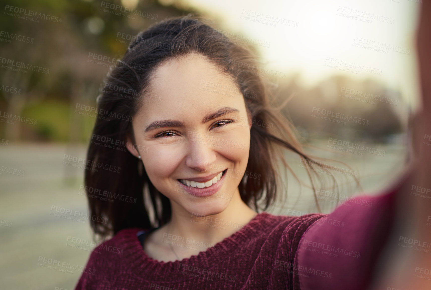 Buy stock photo Portrait of a happy young woman taking a selfie outdoors