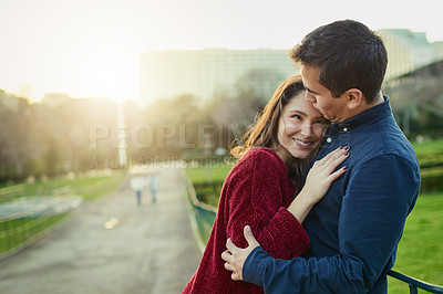Buy stock photo Shot of a happy young couple embracing each other outdoors