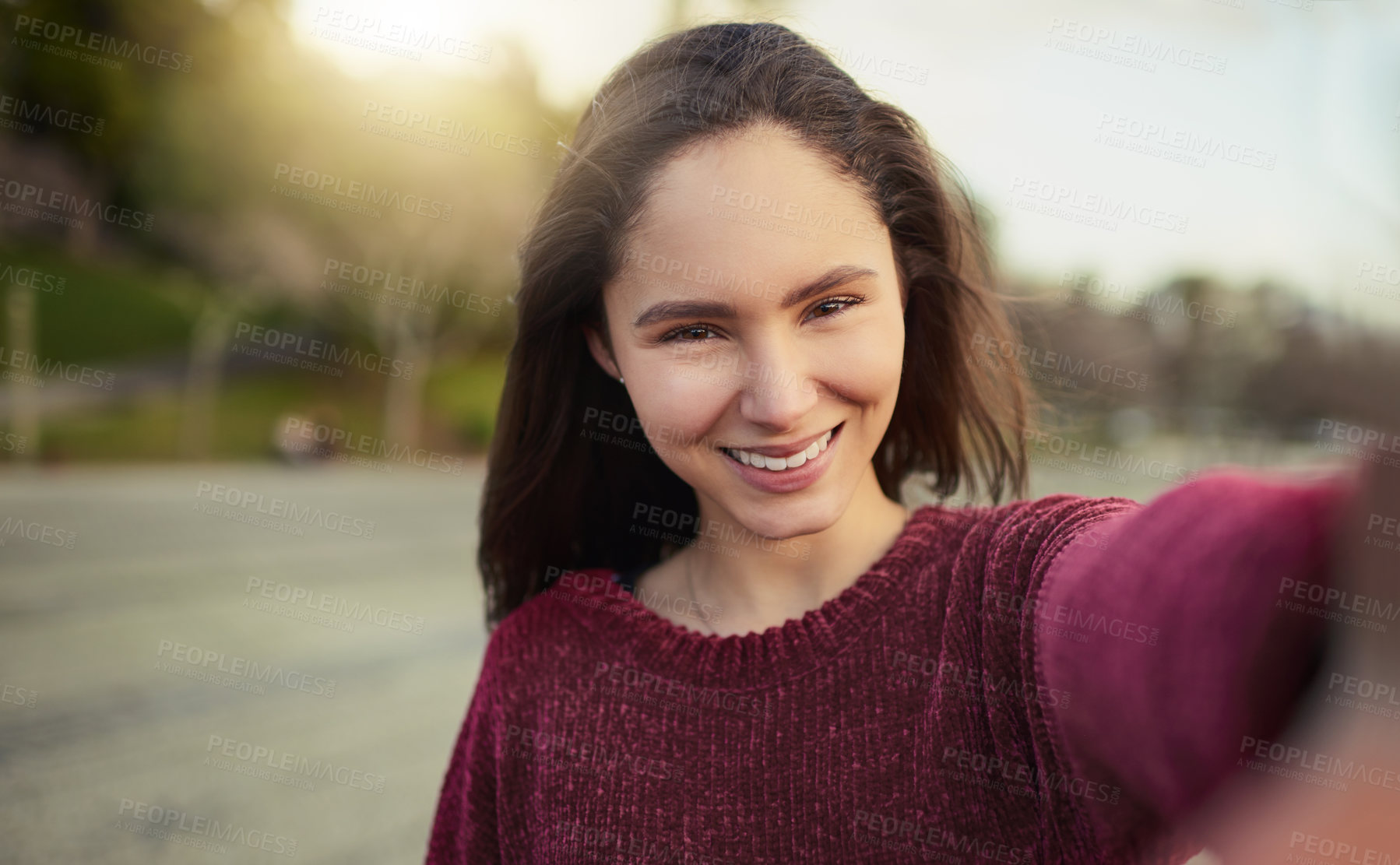 Buy stock photo Portrait of a happy young woman taking a selfie outdoors