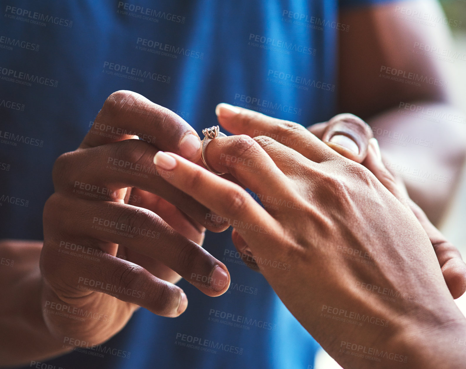 Buy stock photo Closeup shot of an unrecognizable man putting an engagement ring onto his fiancee’s finger
