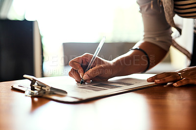 Buy stock photo Closeup shot of an unrecognizable woman filling in paperwork at a table