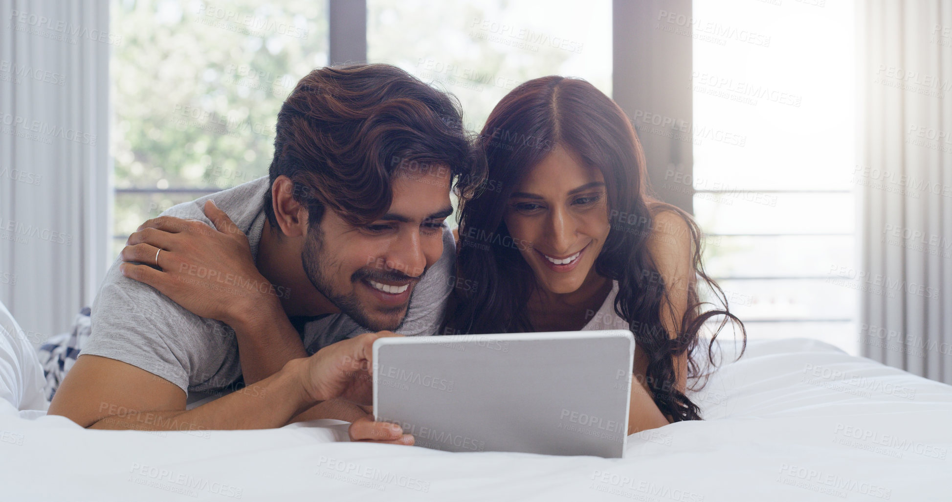 Buy stock photo Shot of a young attractive couple using a tablet together in the bedroom at home