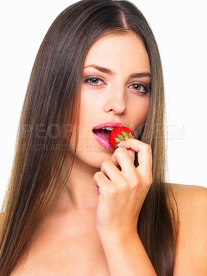 Buy stock photo Studio portrait of a beautiful young woman eating a strawberry against a white background