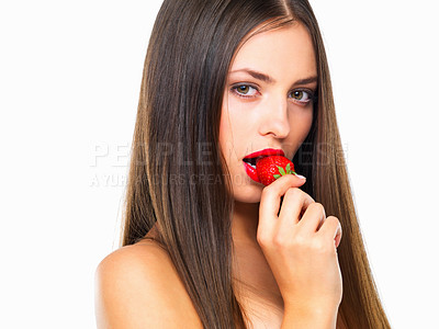 Buy stock photo Studio portrait of a beautiful young woman eating a strawberry against a white background