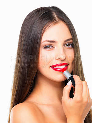 Buy stock photo Studio portrait of a beautiful young woman applying red lipstick against a white background