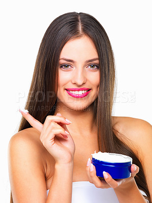 Buy stock photo Studio portrait of a beautiful young woman applying lotion against a white background