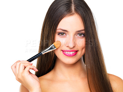 Buy stock photo Studio portrait of a beautiful young woman applying blush against a white background