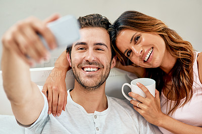 Buy stock photo Shot of a happy young couple taking a selfie together at home