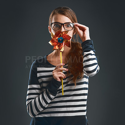 Buy stock photo Portrait, pinwheel and woman with glasses for fashion eyewear and style isolated on black studio background. Face, toy and playful girl with windmill or blowing air fan for game with paper origami