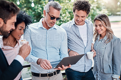 Buy stock photo Shot of a group of businesspeople working together on a laptop outdoors