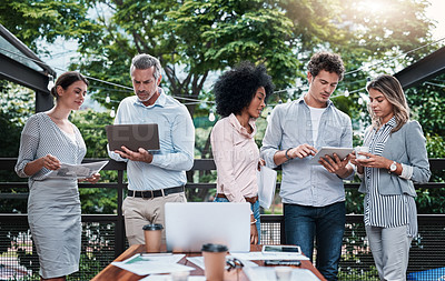 Buy stock photo Shot of a group of businesspeople working together outdoors